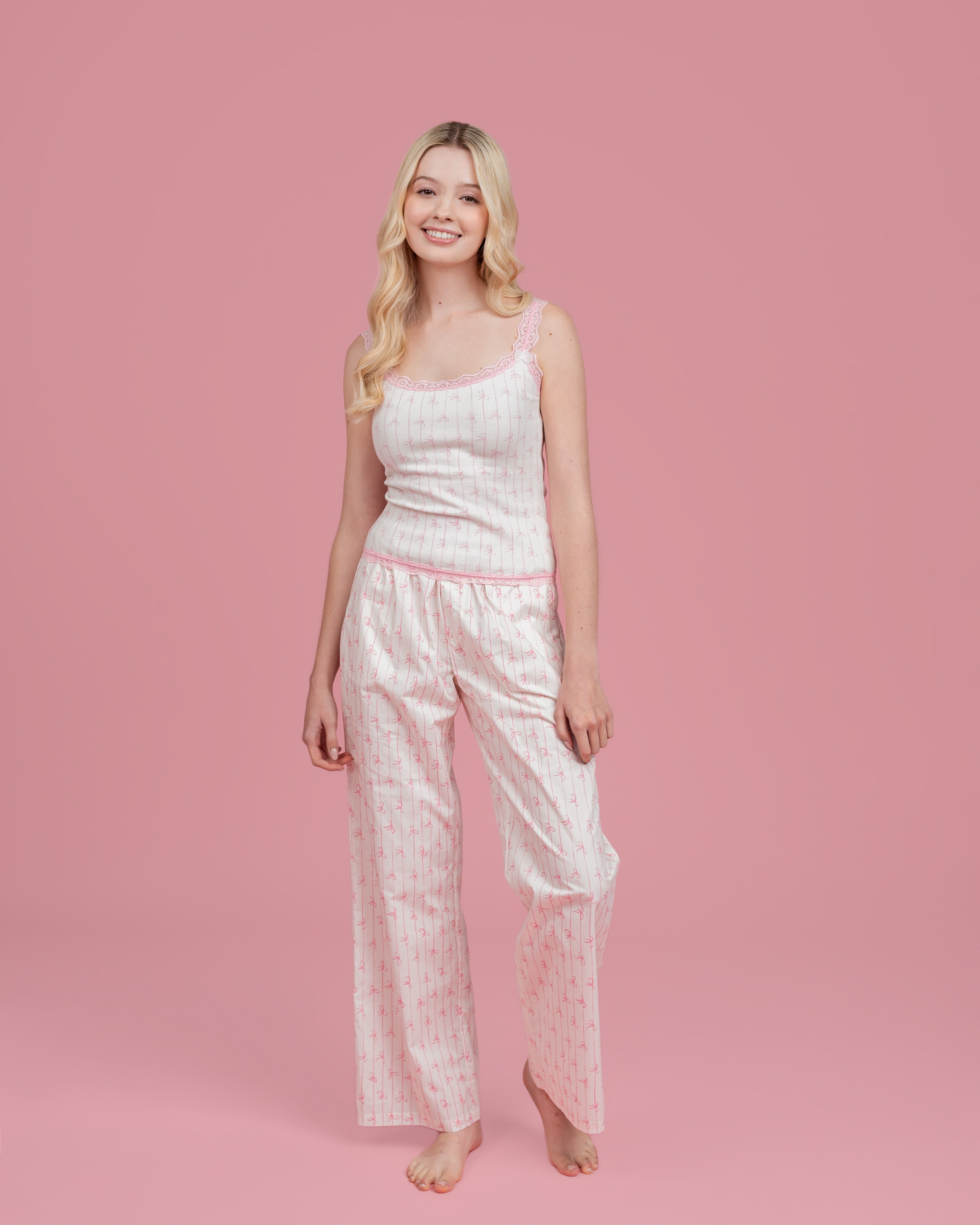 Model wearing Dream Queen Co. Love Lines waffle top in pink bow stripe, and love lines pink bow stripe lounge pant