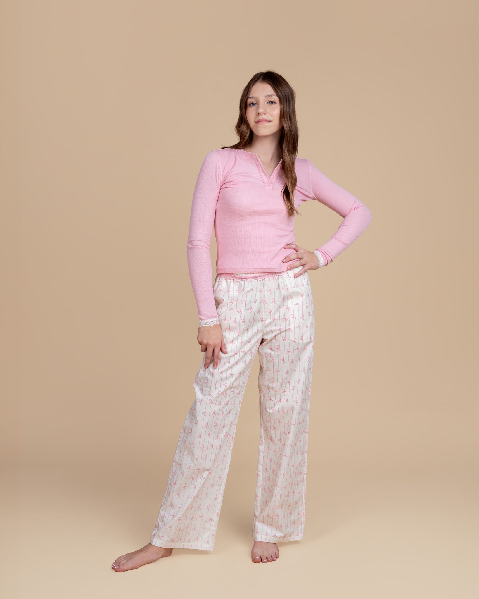 teen model wearing Dream Queen Co. dreamily waffle top in pink, and love lines coquette pink striped lounge pant