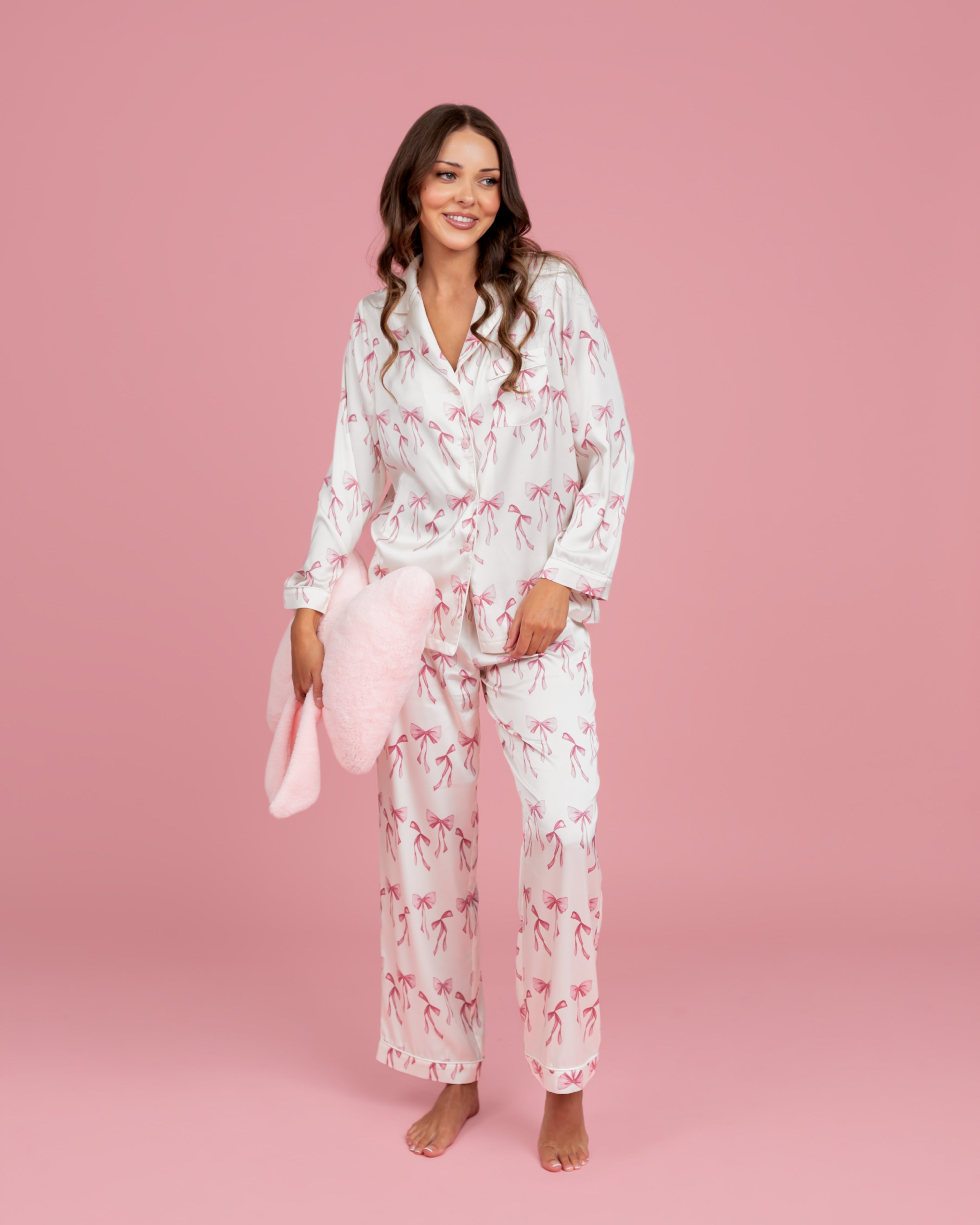 Model wearing Dream Queen Co. Sleep Cute Long sleeve satin PJ set in Coquette Code pink Bow Print