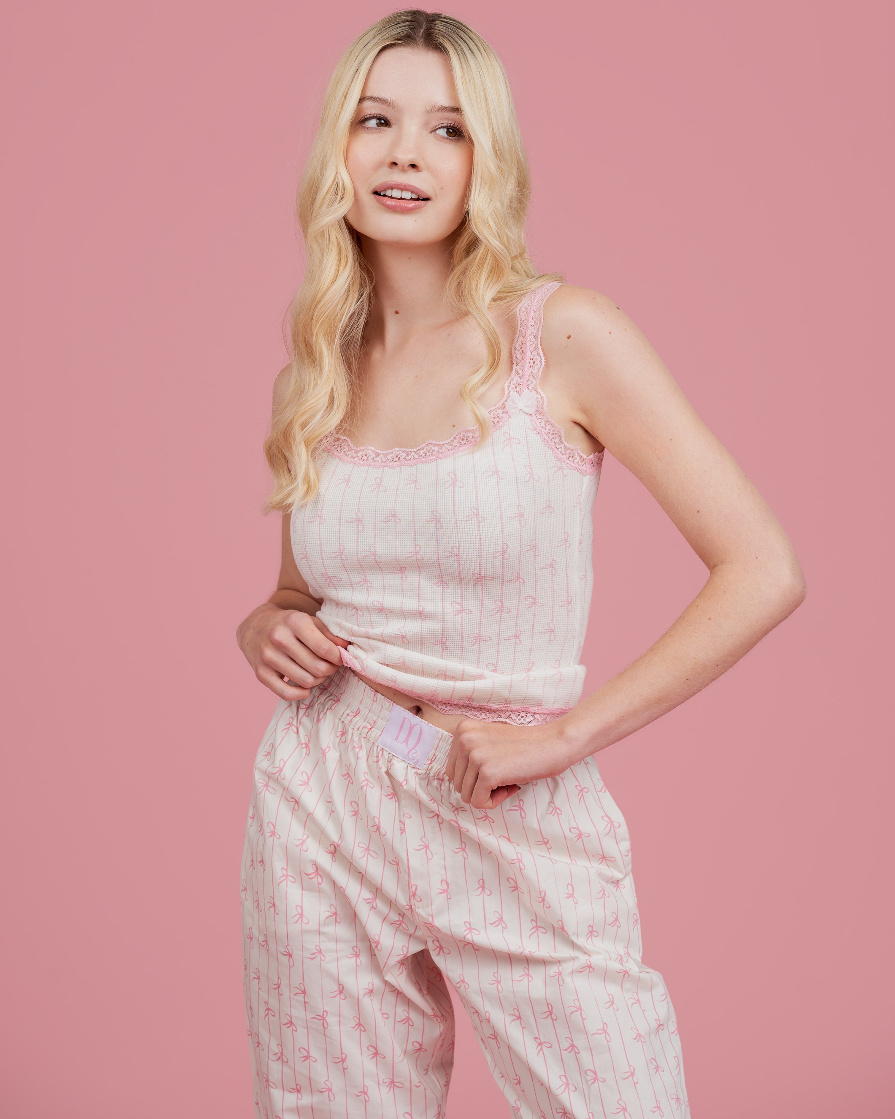 Model wearing Dream Queen Co. Love Lines waffle top in pink bow stripe, and love lines pink bow stripe lounge pant