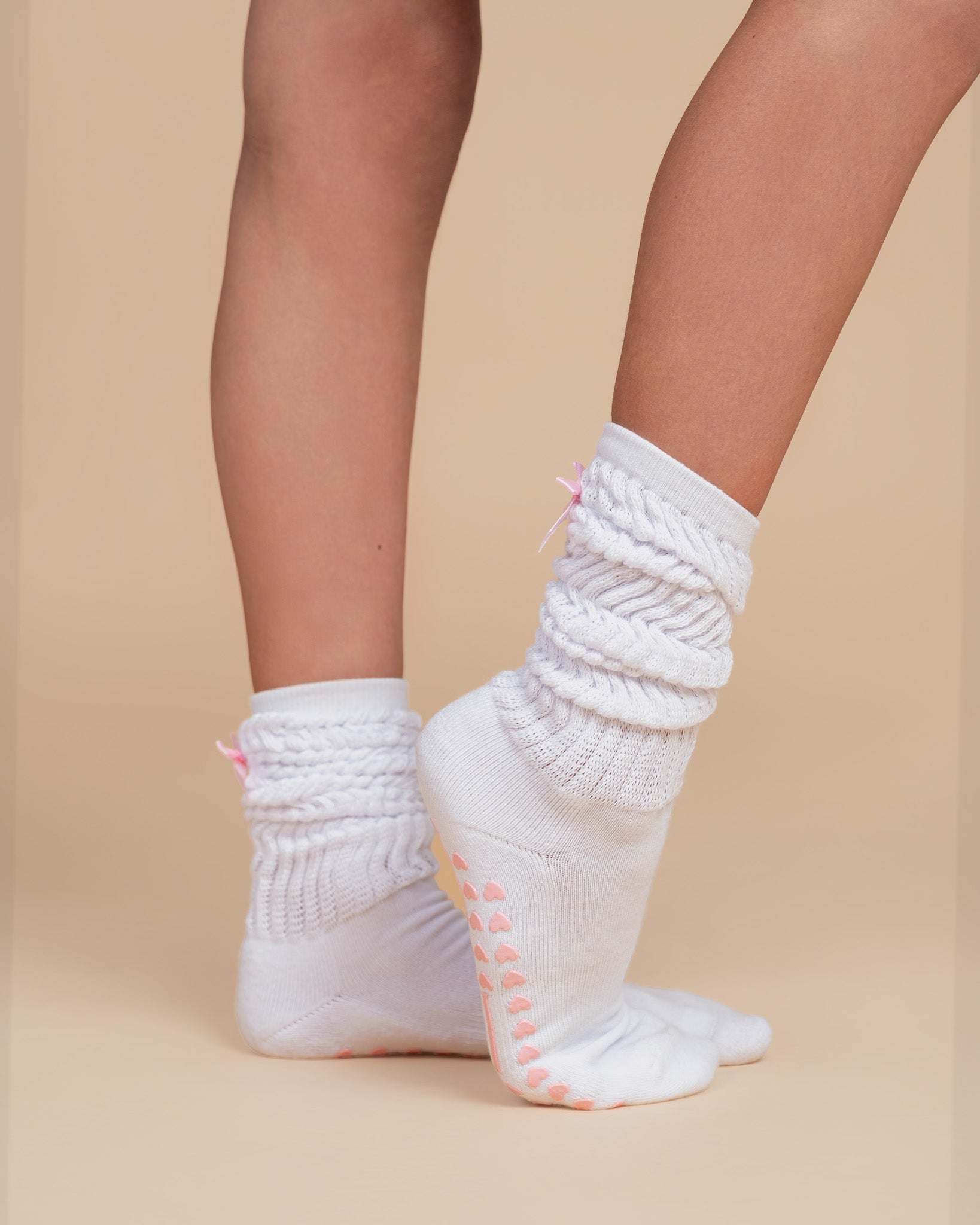 White grip pilates bed socks with pink hearts, logo and pink bow