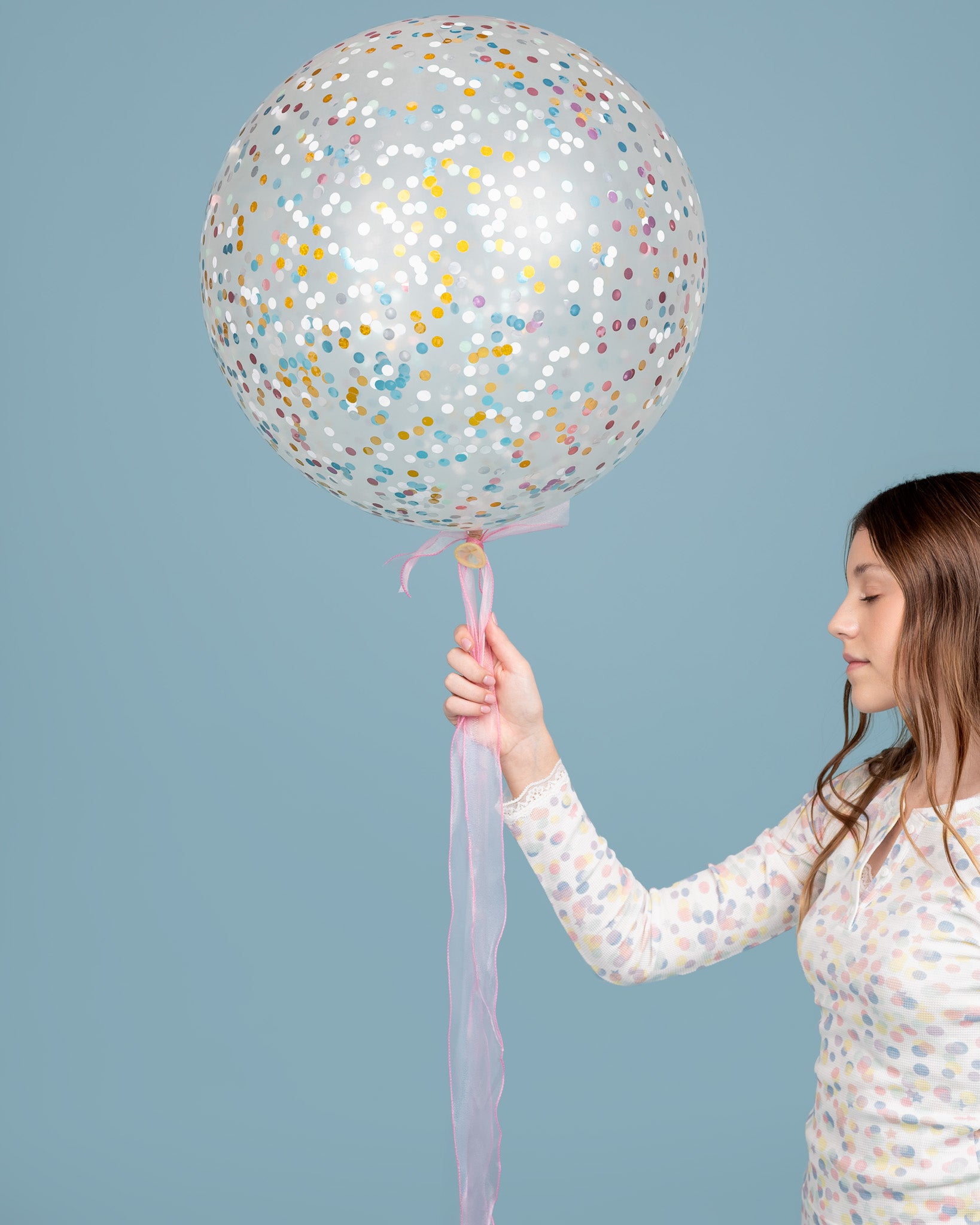 teen model wearing Dream Queen Co. waffle top in pastel confetti crush, holding confetti balloon